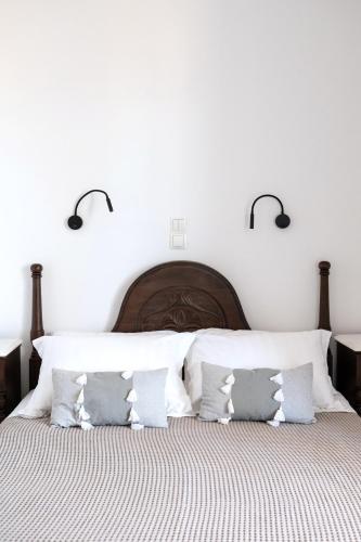 a bedroom with a large bed with white walls at Sea Lilies Suites in Plaka