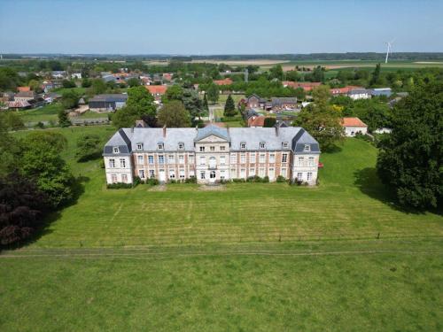 an aerial view of a large house on a green field at Chambres d'hôtes & Gîtes du Château de Grand Rullecourt in Grand Rullecourt