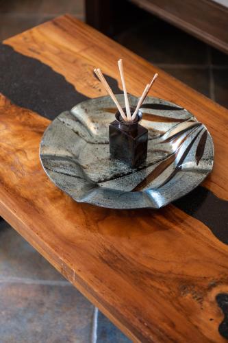 a metal plate on a wooden table with sticks on it at Sea Lilies Suites in Plaka