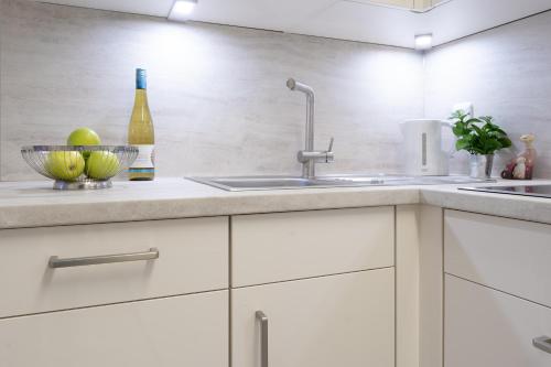 a kitchen with white cabinets and a sink at Haus Eva Mar am Meer Appartement 5 in Timmendorfer Strand