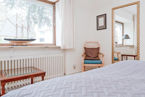 蒂門多爾費爾斯特蘭德的住宿－Haus Eva Mar am Meer Appartement 1，一间卧室设有一张床、一个窗口和一把椅子
