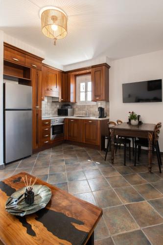 a large kitchen with a table and a refrigerator at Sea Lilies Suites in Plaka