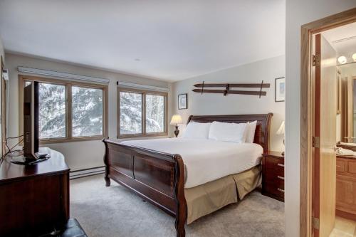 a bedroom with a large bed and two windows at Townsend Place in Beaver Creek