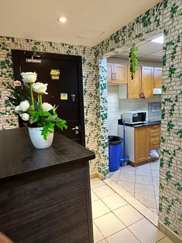 a kitchen with a vase of flowers on a counter at M02 Centre Residance Near Metro in Dubai