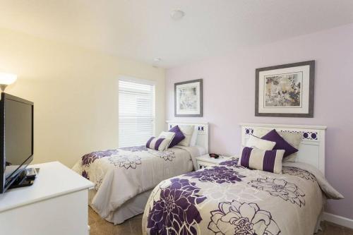a bedroom with two beds and a tv in it at 6Br 6Bath Pvt Home Pool 10min Disney 3282ft in Kissimmee