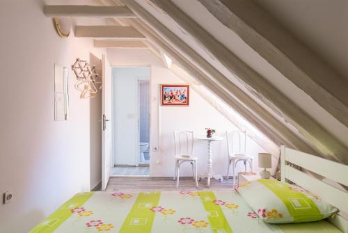 een slaapkamer met een bed en een tafel en stoelen bij Old Town Baroque Palace Accommodation in Dubrovnik