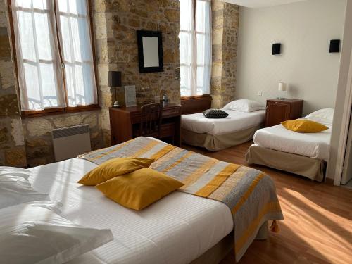 une chambre d'hôtel avec deux lits et des fenêtres dans l'établissement Hôtellerie de l'Abbaye Saint Amand, à Saint-Amand-de-Coly
