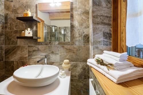 a bathroom with a sink and towels on a counter at Baite Rosa in Alagna Valsesia
