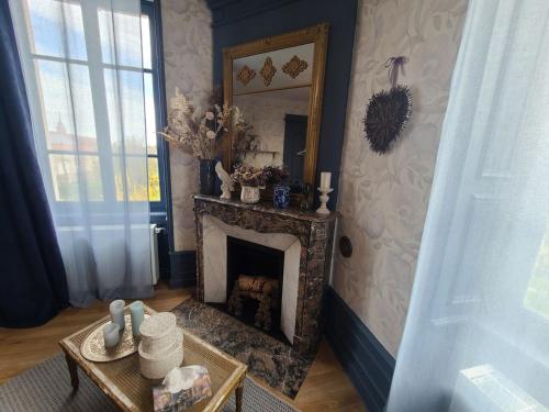 un salon avec une cheminée et un miroir dans l'établissement Chambre cosy avec accueil chaleureux, proche de Vittel et Contrexéville - FR-1-589-480, à Médonville