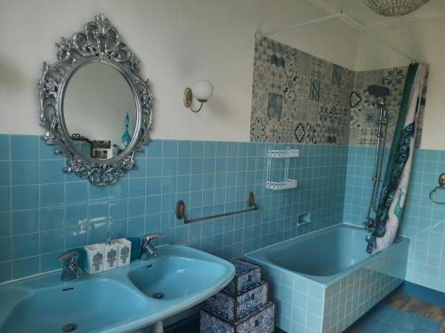 ein blaues Badezimmer mit einem Waschbecken und einer Badewanne in der Unterkunft Guestroom Médonville, 1 pièce, 2 personnes - FR-1-589-480 