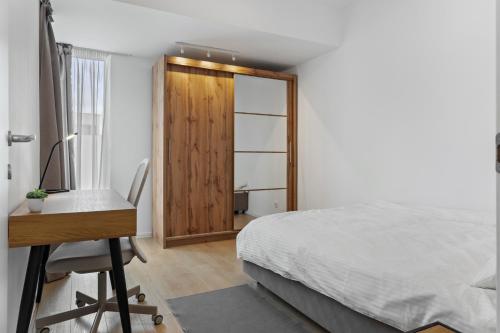 a bedroom with a desk and a bed and a desk and a chair at Atria Urban Gateway, 2BR Condo + Pool in Bucharest