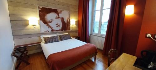 um pequeno quarto com uma cama e uma janela em Logis hôtels Auberge du Château em Saint-Rémy-de-Blot