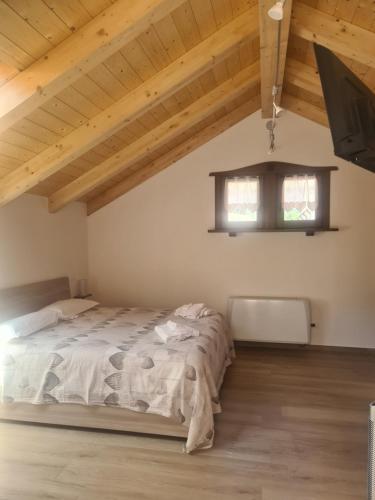 um quarto com uma cama num quarto com tectos em madeira em La casa del gnocco em Masone