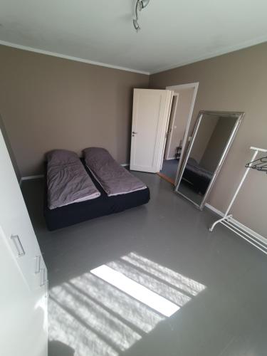 een kleine slaapkamer met een bed en een koelkast bij Leilighet sentralt på Lund i Kristiansand in Kristiansand