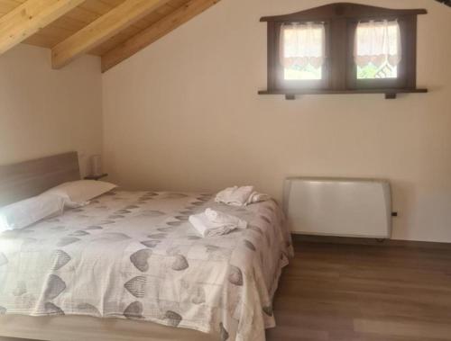 a bedroom with a bed in a room with two windows at La casa del gnocco in Masone