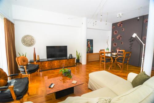 uma sala de estar com um sofá e uma mesa em Φωτεινό κομψό & άνετο διαμέρισμα κοντά στο κέντρο! em Atenas