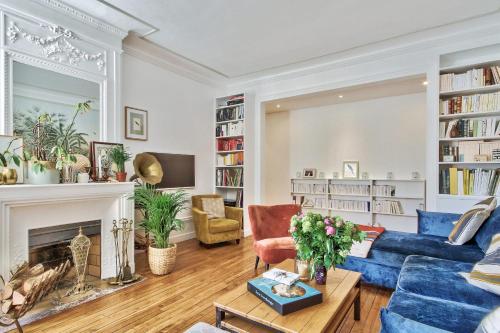 un salon avec un canapé bleu et une cheminée dans l'établissement Appartement Chernoviz - Welkeys, à Paris