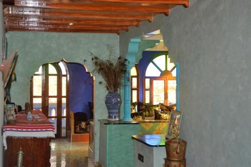 een woonkamer met blauwe muren en ramen en een tafel bij The Sunrise Villa in Agadir