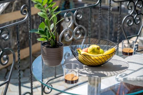 un cesto di frutta su un tavolo di vetro con una pianta di Seaside Guesthouse a Kavala