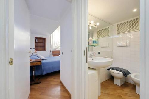 a bathroom with a sink and a toilet and a bed at Suite Barberini in Rome