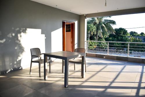 einen Tisch und Stühle auf einem Balkon mit Aussicht in der Unterkunft Cristina´s Home Natural Feelings in Matola