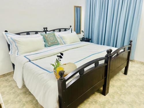 a bedroom with a large bed with blue curtains at Sea Breeze Guest House in Negombo