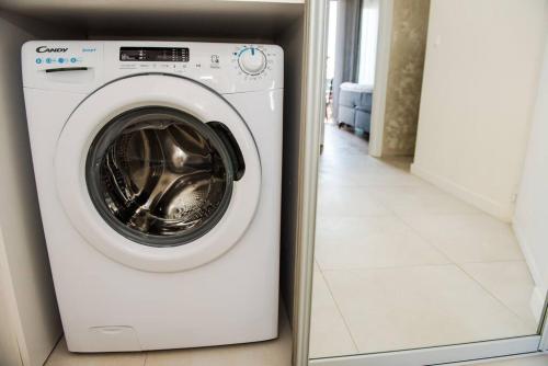una lavadora y secadora blancas en una habitación en Apartment with a sea view., en Tivat