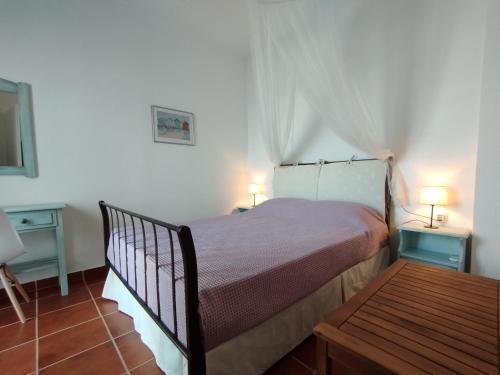 a bedroom with a bed and two tables and two lamps at Light Blue in Makry Gialos
