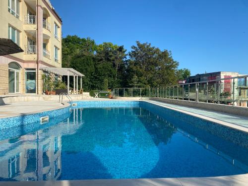 una gran piscina azul junto a un edificio en ATEA Apartments en Kavarna