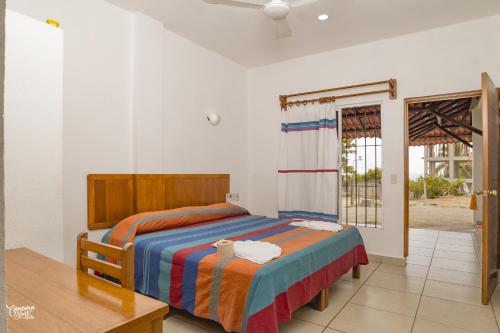 um quarto com uma cama e uma porta de vidro deslizante em Hotel VidaMar em Puerto Escondido