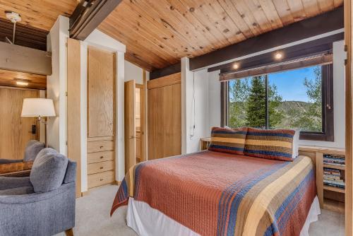 a bedroom with a bed and a window and a chair at Laurelwood Condominiums 311 in Snowmass Village