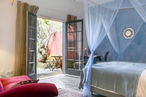 Schlafzimmer mit einem Bett mit blauen Vorhängen in der Unterkunft Estrela do Atlântico in Horta