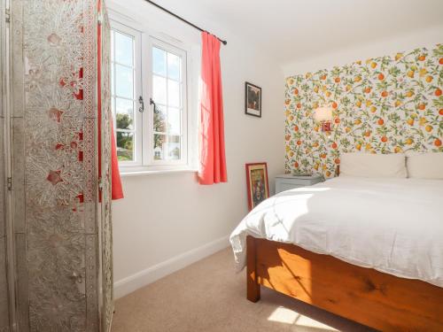 een slaapkamer met een bed en een raam bij Cherry Garden Cottage in Cranbrook