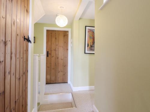 a hallway with a wooden door in a house at Cherry Garden Cottage in Cranbrook