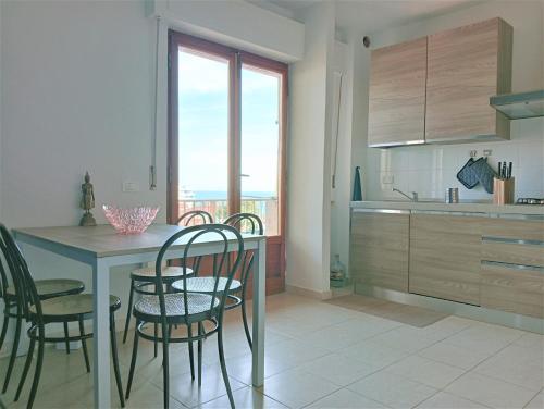 a kitchen with a table and chairs and a kitchen with a window at Appartamento a 50 mt dal mare in Rosignano Solvay