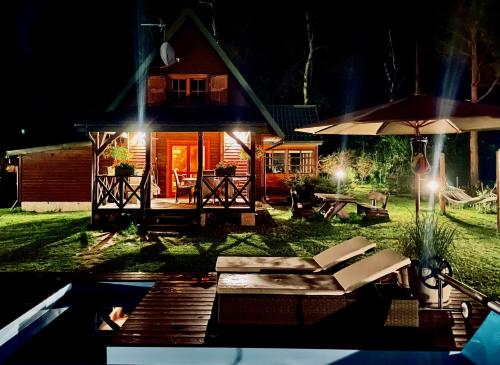 a house at night with a table and an umbrella at Leśny Raj in Świętajno