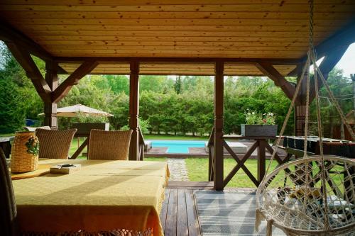 a wooden pavilion with a table and a pool at Leśny Raj in Świętajno