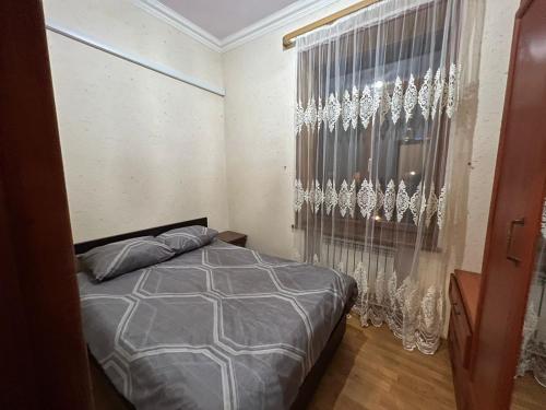 a bedroom with a bed and a window with curtains at One bedroom Apartment in the centre of Yerevan, Amiryan Street 5a in Yerevan