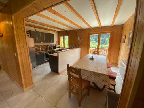 une cuisine et une salle à manger avec une table et des chaises dans l'établissement Chalet 5 Chambres à Châtel avec Multi Pass Été et 4 Salles de Bain – Confort et Charme Alpins - FR-1-693-1, à Châtel