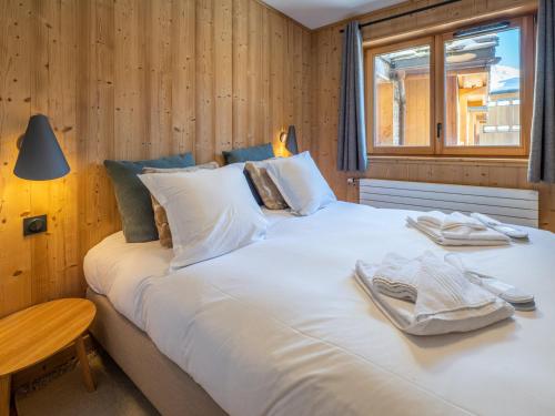 une chambre avec un grand lit blanc avec une fenêtre dans l'établissement Ski-in/Ski-out à l'Alpe d'Huez: Appartement 130m² avec Piscine, Sauna et Hammam - FR-1-645-21, à Huez