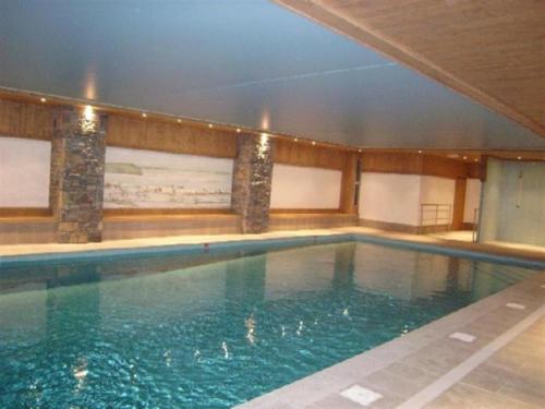 une grande piscine avec de l'eau bleue dans un immeuble dans l'établissement Appartement 6 pers, piscine, 3 pièces, balcon, parking - FR-1-733-121, à Crest-Voland