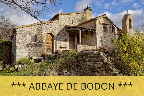 une vieille maison en pierre sur une colline avec les mots abbaye de bourbon dans l'établissement Abbaye de Bodon - Provence, à Saint-May