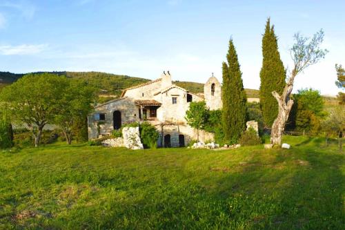 une ancienne maison en pierre dans un champ d'herbe verte dans l'établissement Abbaye de Bodon - Provence, à Saint-May
