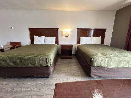 a hotel room with two beds and a table at Llano Motel in Llano