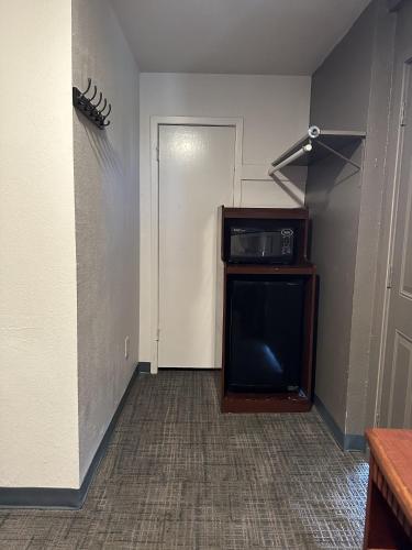 a living room with a tv and a door at Llano Motel in Llano