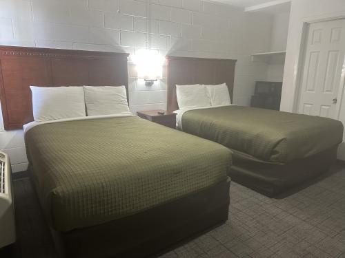 a hotel room with two beds and a lamp at Llano Motel in Llano