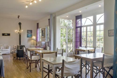 een eetkamer met tafels en stoelen en ramen bij Estrela do Atlântico in Horta