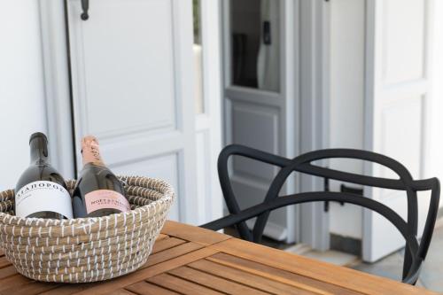 a basket of wine bottles on a wooden table at Sea Lilies Suites in Plaka