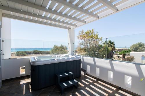 a hot tub on a balcony with a view of the ocean at Sea Lilies Suites in Plaka