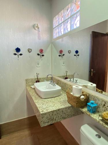 a bathroom with two sinks and a toilet at Chalé Château do Luí in Monte Verde